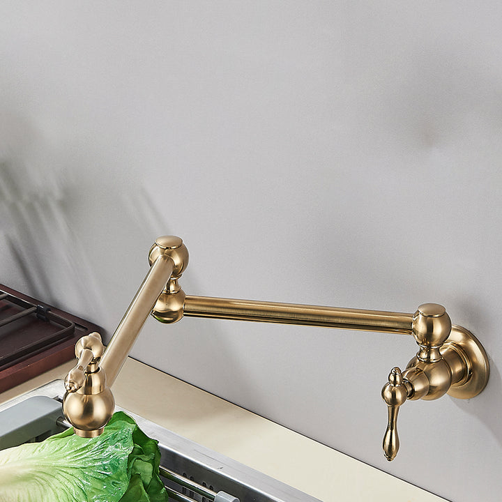 Un robinet mural en laiton doré brossé pour évier de cuisine, rabattable et encastrable. Contrôle précis du débit et de la température de l'eau grâce à ses deux poignées de mitigeur. Rotation à 360° pour une flexibilité maximale. Idéal pour les cuisines avec espace limité.