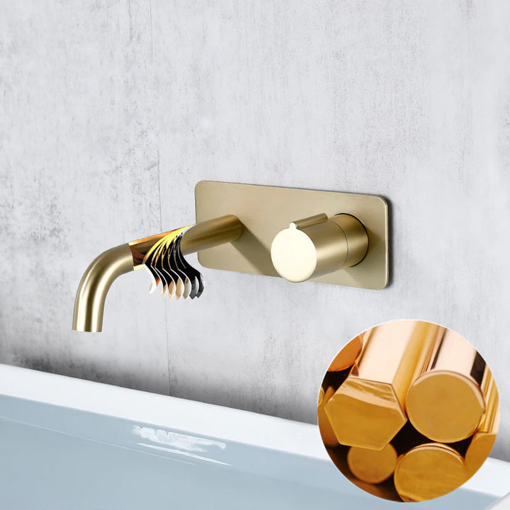 Un robinet mural en laiton doré avec un tube doré et une plaque rectangulaire arrondie. Bouton pour la gestion de la température et du débit. Parfait pour une salle de bain élégante.