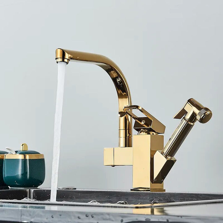 Un robinet évier cuisine doré brillant avec eau qui coule et douchette pistolet flexible. Design luxueux avec bec pivotant à 360°.