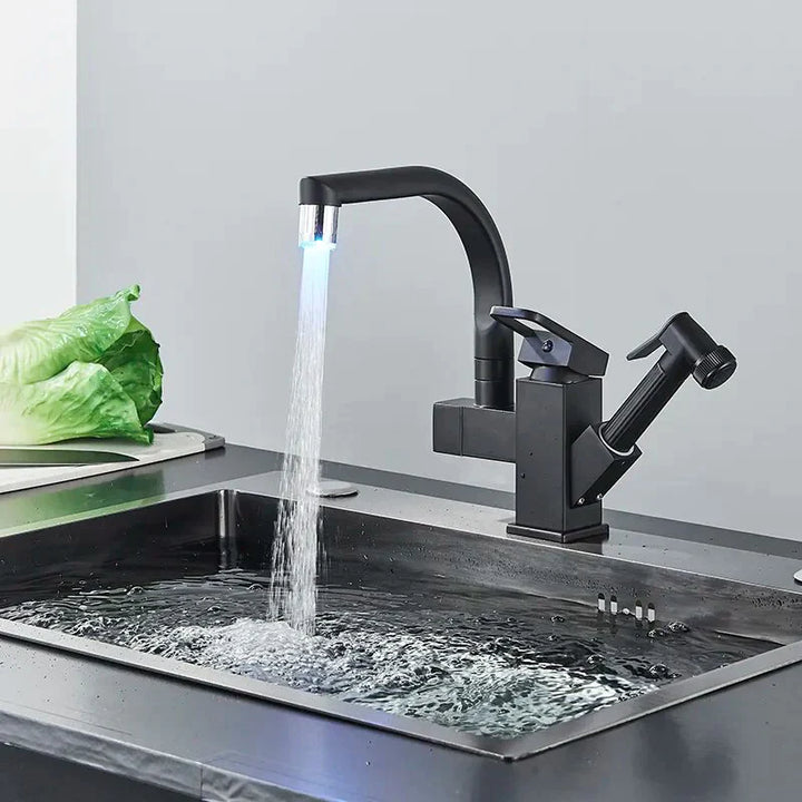 Un évier de cuisine noir avec un robinet qui coule de l'eau.