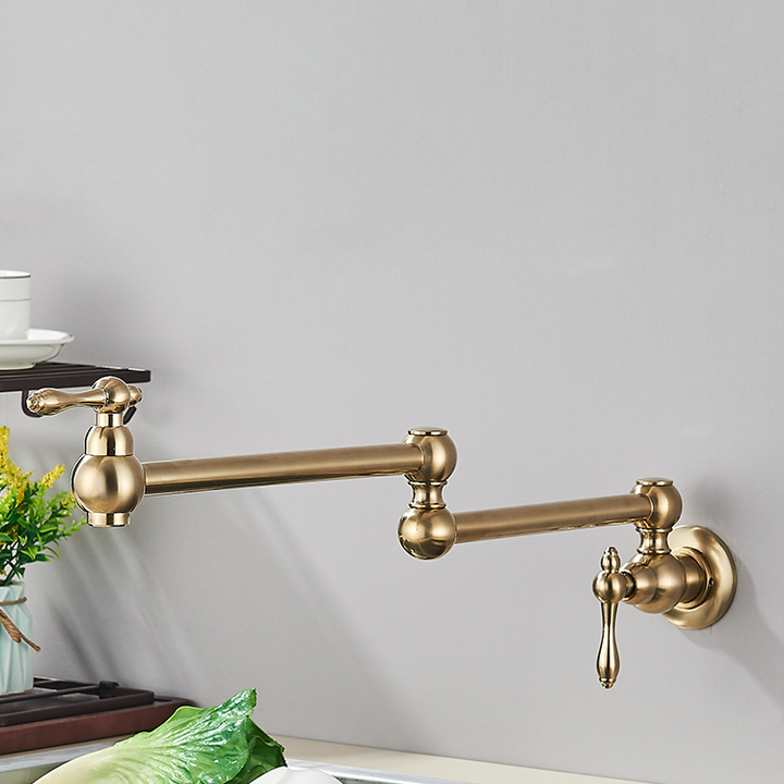 Un robinet mural en laiton doré brossé pour cuisine évier rabattable rétro. Design encastrable avec rotation à 360° et contrôle précis du débit et de la température de l'eau. Idéal pour les cuisines où l'espace est une considération primordiale.