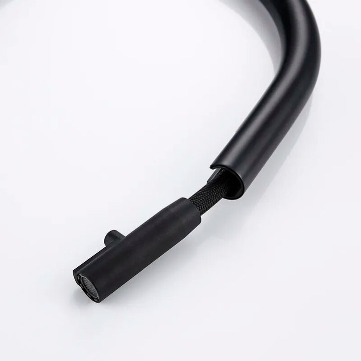 Un câble noir avec une corde en caoutchouc flexible pour robinet évier cuisine minimaliste mitigeur déporté en laiton noir mat.