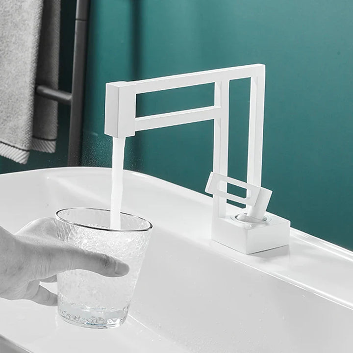 Un robinet blanc moderne et géométrique pour lavabo est installée dans une salle de bain. 