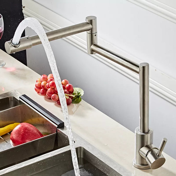 Un robinet pour évier de cuisine avec de l'eau qui coule. Design élégant en acier inoxydable argenté brossé. Pivots à 360° pour une flexibilité inégalée. Poignée latérale pour réguler le débit et la température de l'eau. Parfait pour toute cuisine moderne.