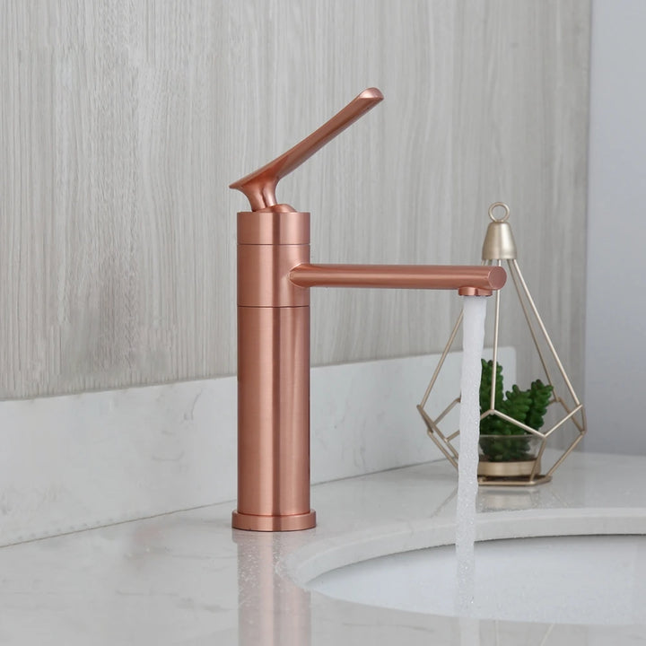 Dans une salle de bain moderne, un robinet doré rose est installé design avec une poignée sur le haut.