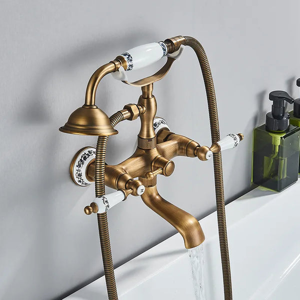 Un robinet doré avec eau qui coule, poignées anciennes et douchette rétro pour baignoire salle de bain céramique - Atelier Du Robinet