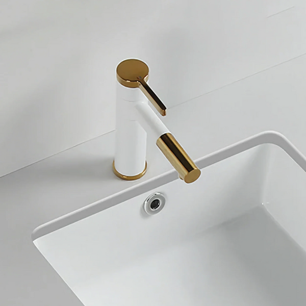 Dans une salle de bain, un robinet bicolore blanc et doré de style simple est installé. 