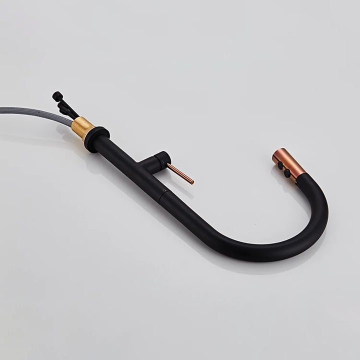 Un robinet évier cuisine avec douchette dorée rose et bec noir cylindrique en laiton. Design minimaliste et élégance contemporaine. Dimensions : 437 x 218 mm.