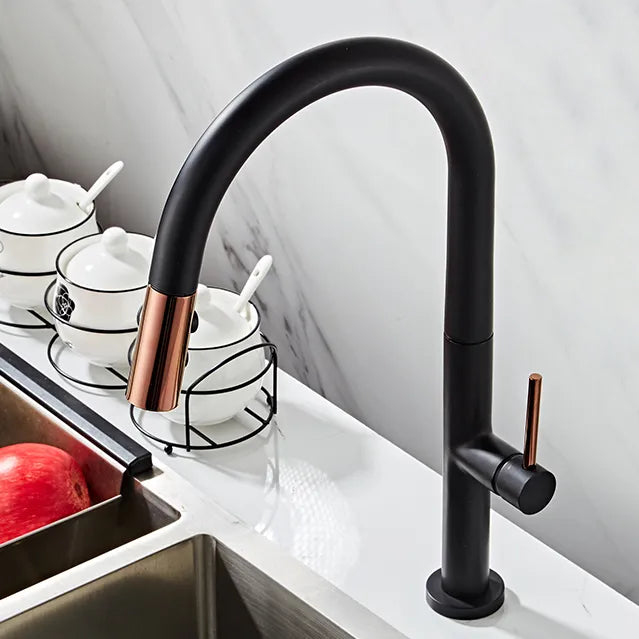 Un robinet évier noir avec une douchette dorée rose brillante et un bec cylindrique. Design minimaliste et élégance contemporaine pour votre cuisine.