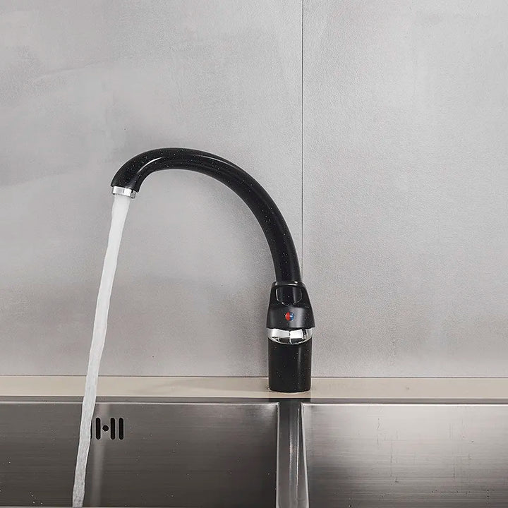 Un robinet évier de cuisine arrondi avec de l'eau qui coule - Noir moucheté en laiton. Design rétro et fonctionnalité moderne pour une cuisine élégante.