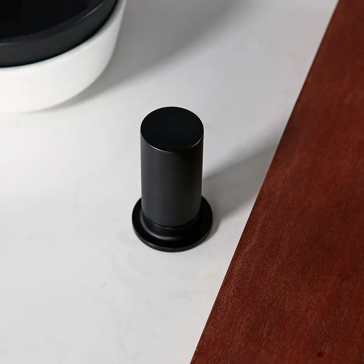 Robinet évier cuisine minimaliste flexible mitigeur déporté en noir mat sur une surface blanche