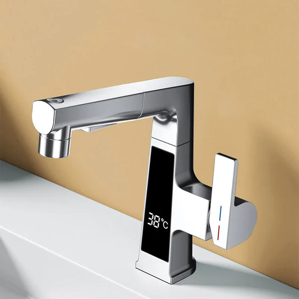 Dans une salle de bain au mur beige, un robinet argenté chromé est installé. Il a un affichage numérique de la température. Il a une poignée sur le côté. 