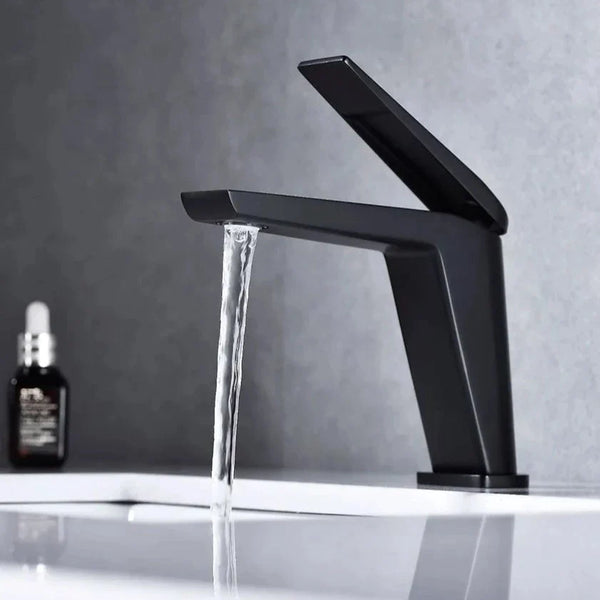 Un robinet lavabo minimaliste en laiton noir mat avec de l'eau qui coule. Parfait pour une salle de bain élégante et fonctionnelle.