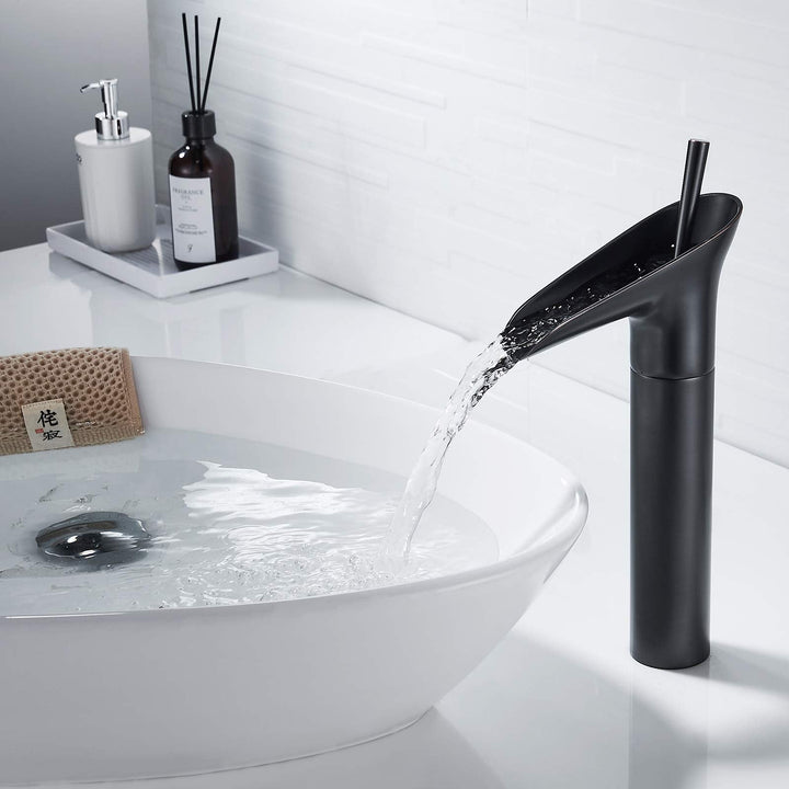 Un robinet noir mat en cascade sur un lavabo en bambou, évoquant la sérénité des jardins zen. L'eau s'écoule en cascade, rappelant le murmure d'une chute d'eau naturelle. Un design sophistiqué pour une expérience relaxante.