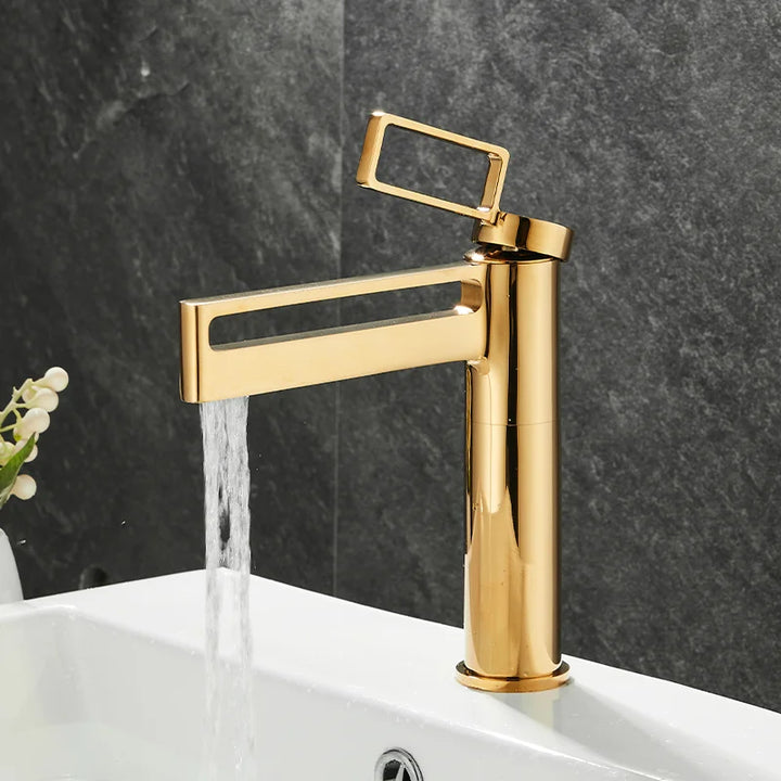 Dans une salle de bain moderne, un robinet géométrique et minimaliste est doré brillant.