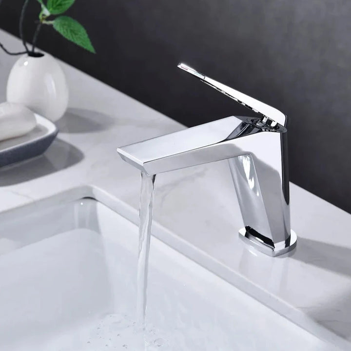 Un robinet lavabo minimaliste en laiton argenté chromé avec un mitigeur rectangulaire sur le dessus. Filtre aérateur nid d'abeille pour une sortie d'eau fluide et agréable. Parfait pour une salle de bain au design minimaliste. Dimensions : 166 x 140 mm. Poids : 1,135 kg.