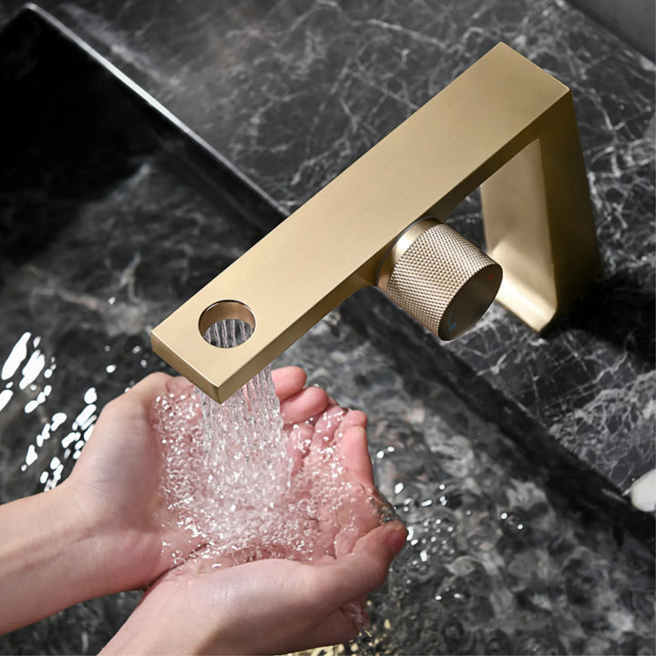 Un robinet de lavabo doré brossé au design contemporain avec un écoulement en multijet. Parfait pour élever le style de votre salle de bain.