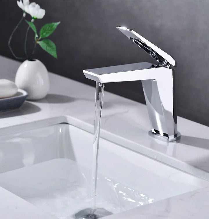 Un robinet lavabo minimaliste en laiton argenté chromé avec un mitigeur rectangulaire sur le dessus. Filtre aérateur nid d'abeille pour une sortie d'eau fluide et agréable. Parfait pour une salle de bain au design minimaliste et une finition argentée impeccable. Dimensions : 166 x 140 mm. Poids : 1,135 kg.