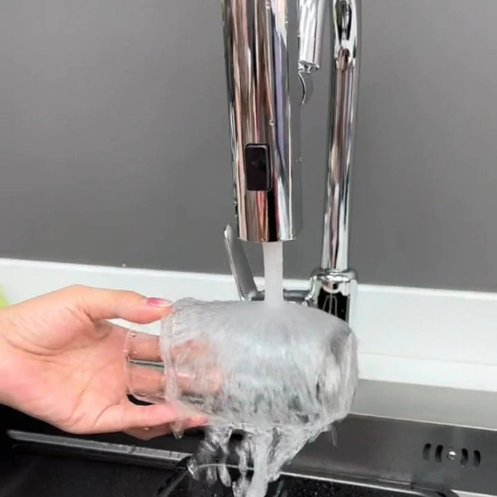Une main lave un verre avec de l'eau. Rallonge de robinet pivotant 3 modes jet - Argenté. Parfait pour la cuisine ou la salle de bain, cette rallonge en acier inoxydable offre une grande flexibilité avec sa fonction pivotante à 360° et trois modes de jets différents.