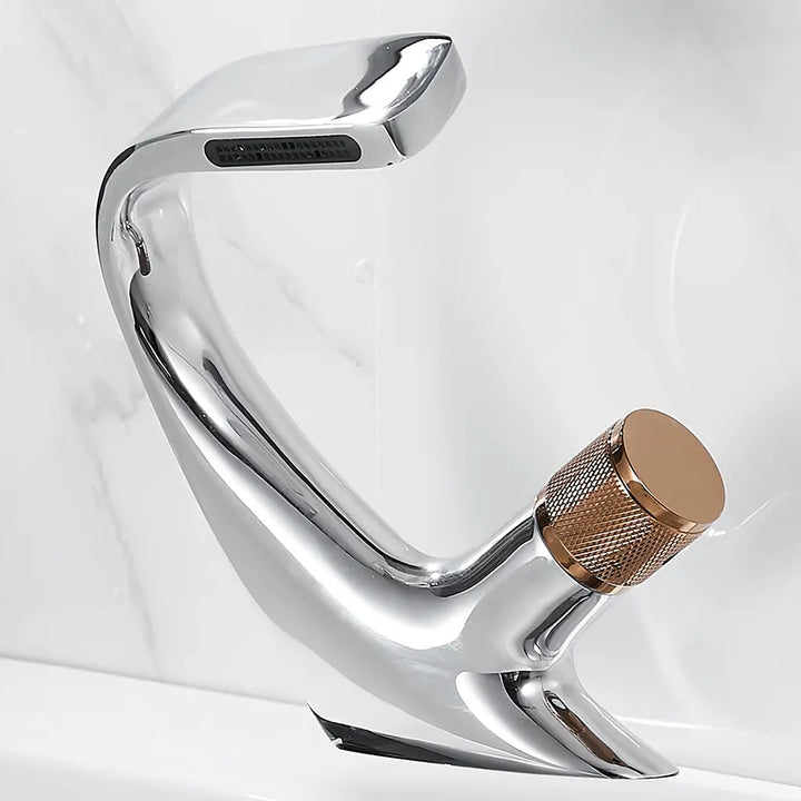 Un robinet lavabo salle de bain incurvé avec une poignée en or et une finition argentée. Design moderne et élégant pour une fonctionnalité optimale.